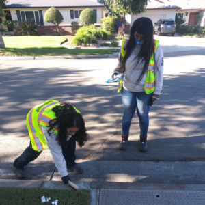 LCC Corpsmembers install safety placards to storm drains