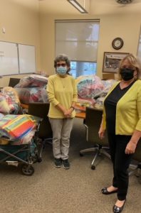 Photo of two people from Foster Grandparent Program helping to gather blankets for Project Linus